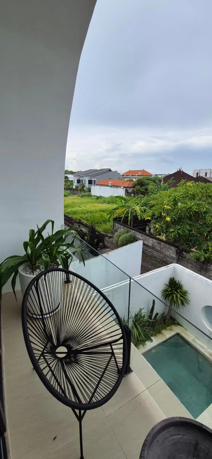 Upstairs balcony with acapulco chair overlooking rice fields and the pool